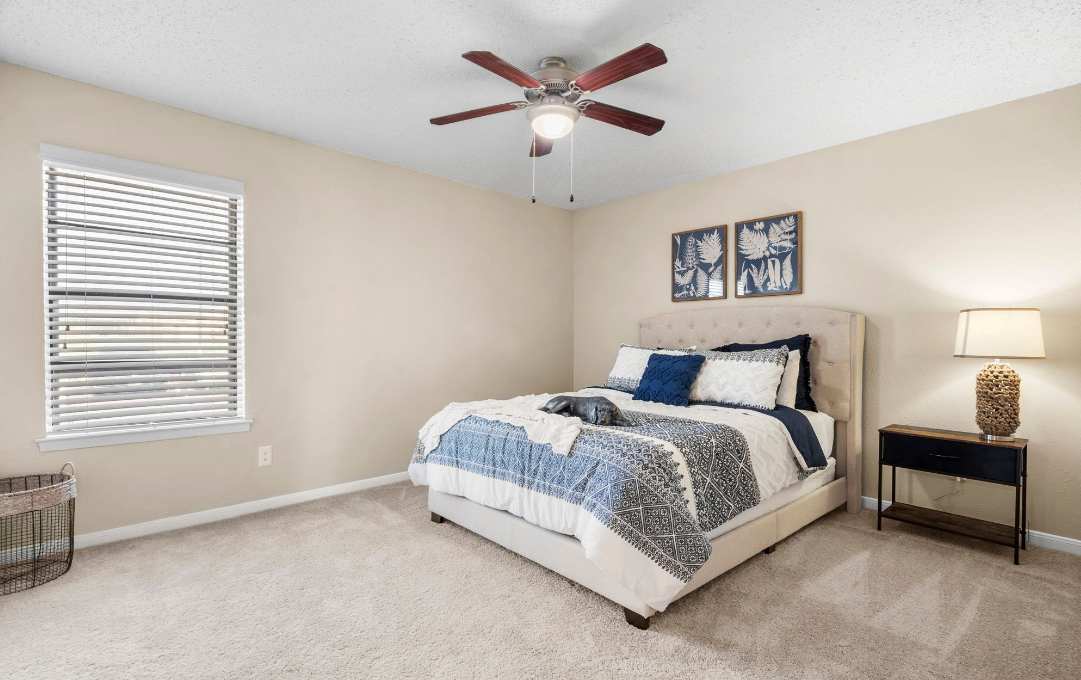 a bedroom with a ceiling fan and carpeted floor at The Brookbend