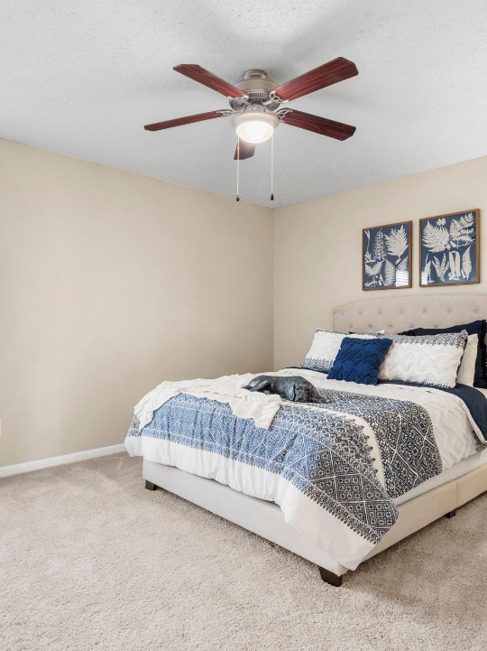 a bedroom with a ceiling fan and carpeted floor at The Brookbend