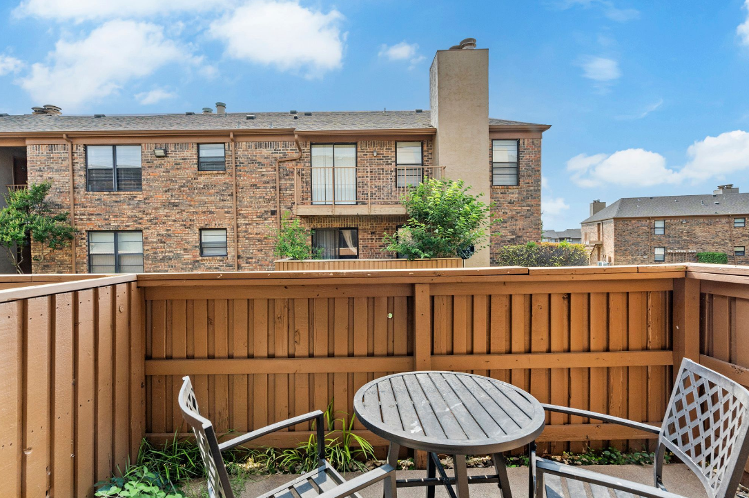 patio with table and chairs in front of a building at The Brookbend