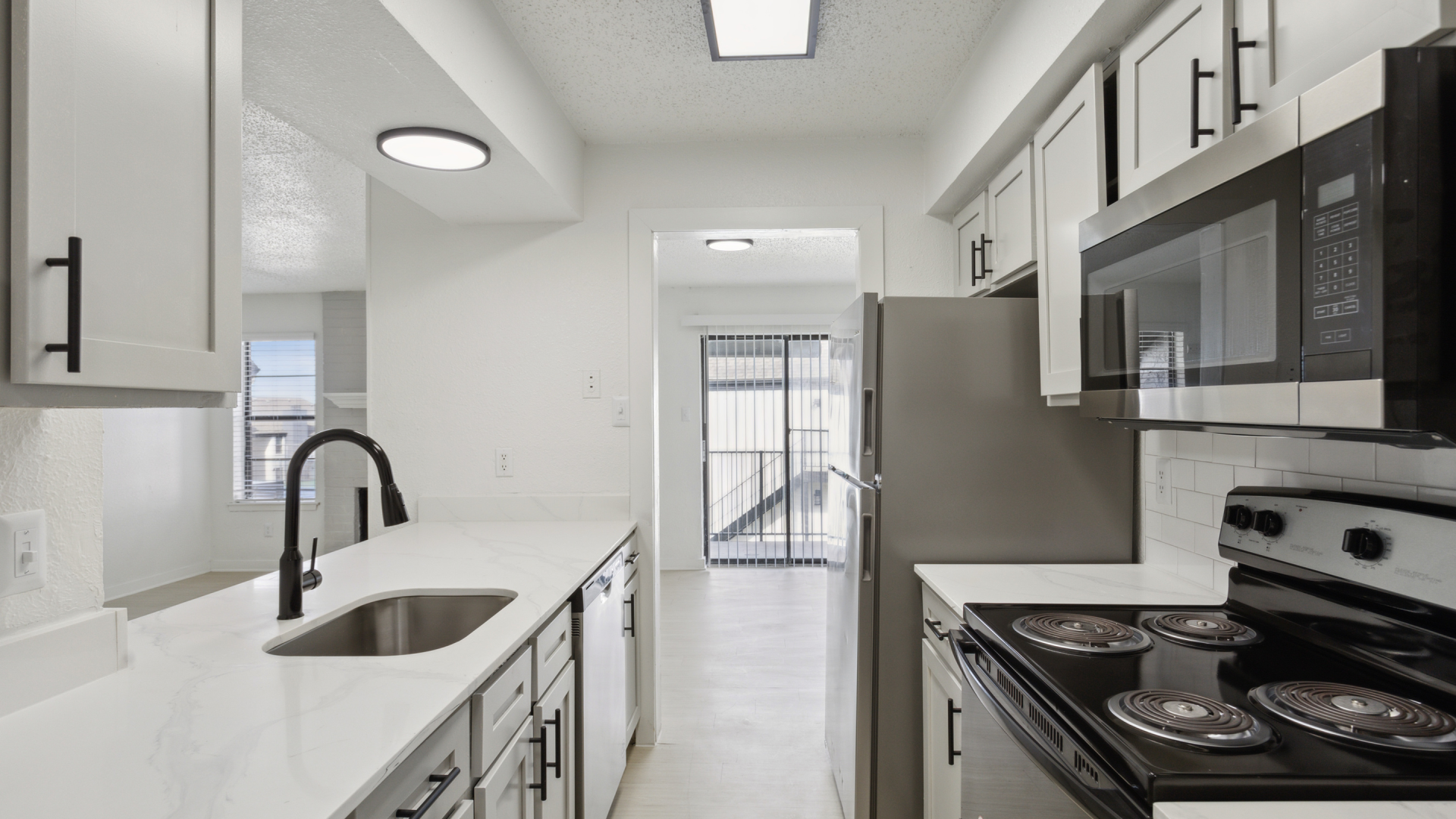 a kitchen with stainless steel appliances and white cabinets at The Brookbend