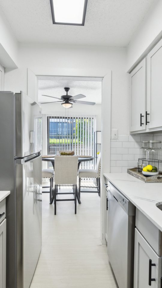 a kitchen with stainless steel appliances and white cabinets at The Brookbend