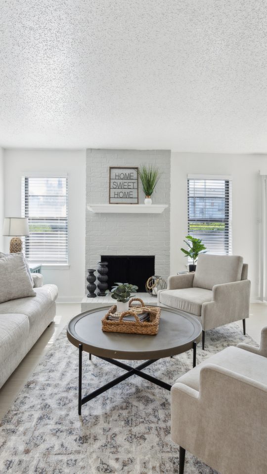 a living room with white furniture and a ceiling fan at The Brookbend